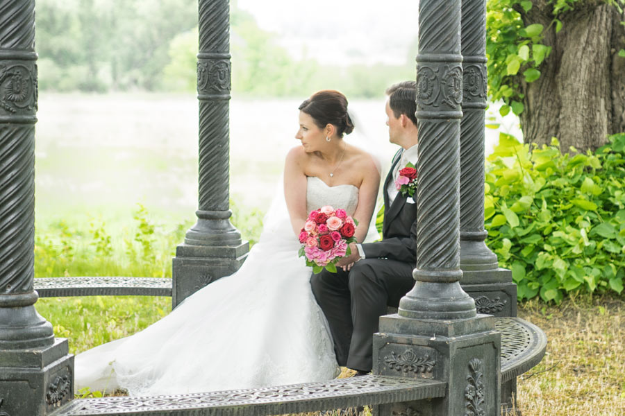 Hochzeitspaar unter Pavillon mit Brautstrauss